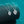 Heart-shaped diamond pendants on silver chains against a teal background