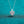 Heart-shaped diamond pendant on a chain against a teal background