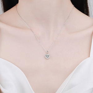 Silver heart-shaped pendant necklace on a mannequin with a white top.