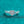 Silver ring with a heart-shaped diamond on a teal glittery background