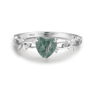 Silver ring with a green heart-shaped stone on a white background