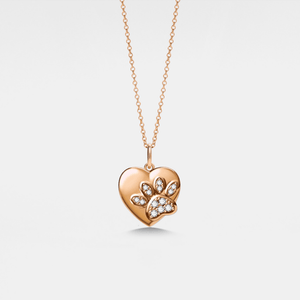 Rose gold heart-shaped locket pendant with a paw design on a light gray background
