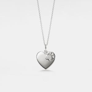 Heart-shaped locket pendant with paw print design on a chain against a light gray background