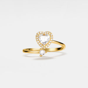 Gold ring with heart-shaped diamond on a light gray background