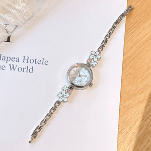 Silver watch with floral designs on a white surface