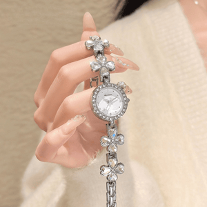 Silver watch with floral designs on a blurred background