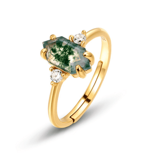 Gold ring with a green gemstone and two small diamonds on a white background