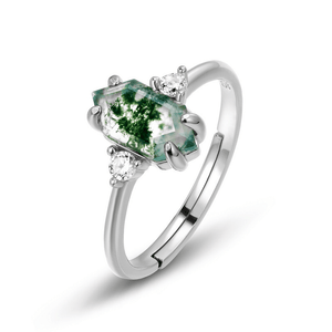 Silver ring with a green gemstone and small diamonds on a white background