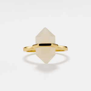 Gold ring with a geometric stone on a white background