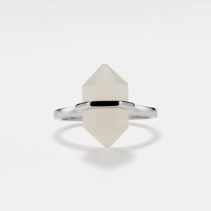 A hexagon-shaped moonstone crystal set in a gold-plated ring with a gold band.