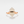 A hexagon-shaped moonstone crystal set in a gold-plated ring with a gold band.