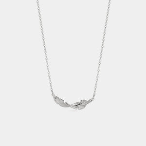 Silver feather necklace on a light gray background
