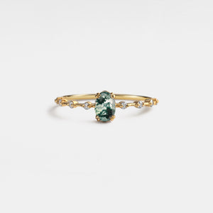 Gold ring with a green gemstone on a white background