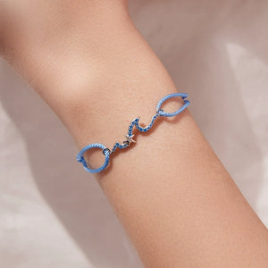 Blue starfish wave charm bracelet on a person's wrist against a neutral background