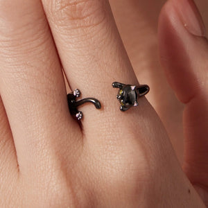 Black cat-shaped wrap ring on a person's finger