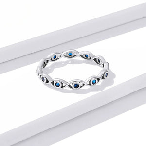 Silver evil eye ring with blue gemstones on a white background