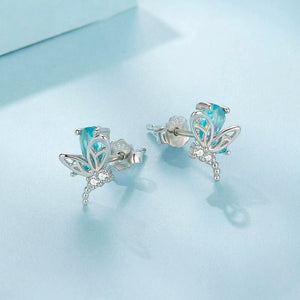 Silver earrings with blue gemstones on a light blue background