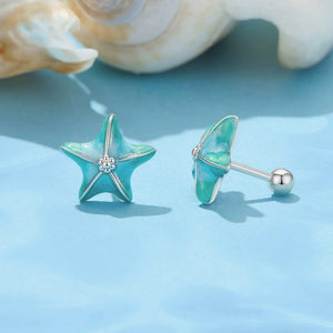Turquoise starfish-shaped earrings on a light blue background with seashells.