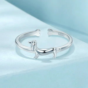 Silver ring with a dachshund dog design on a blue background