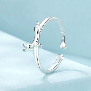 Silver ring with a dachshund dog design on a blue background