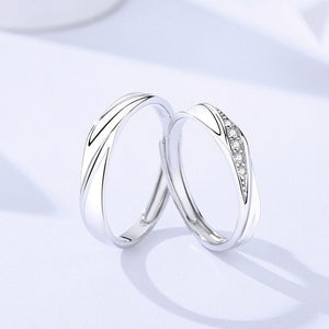 Two silver rings with diamond accents on a light blue background