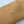 Gold bracelet with a heart-shaped clasp on a wrist against a light background