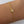 Gold bracelet with a letter 'A' charm on a wrist against a white background