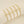 Gold bracelets with letter charms on a beige background