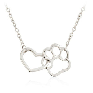 A collection of Interlock Dog Paw Heart Pendant Necklaces in silver and gold colors displayed on a dark background.