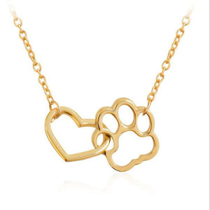 A collection of Interlock Dog Paw Heart Pendant Necklaces in silver and gold colors displayed on a dark background.