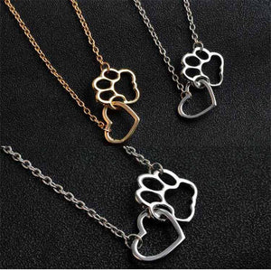 Three paw print and heart pendant necklaces on a black background