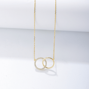 Gold necklace with interlocking rings on a light gray background