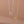 Two heart-shaped pendants on gold and silver chains against a brown background