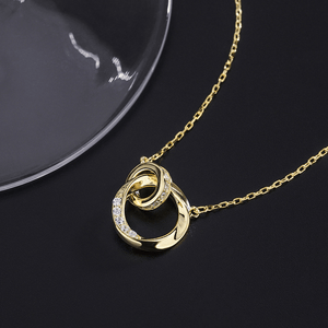 Gold necklace with a intricate pendant on a black background