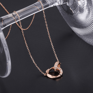 Rose gold necklace with a heart-shaped pendant on a dark background