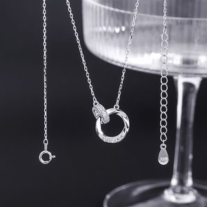 Silver necklace with a circular pendant on a dark background