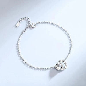 A matching set of interlocking ring bracelets, one with a black cord and another with a silver chain, laid on a white surface.