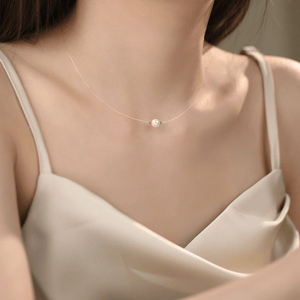 Pearl necklace on a person wearing a beige top