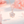 Rose gold necklace with a floral pendant on a soft pink background