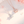 Two floral necklaces, one silver and one rose gold, on a soft pink background.