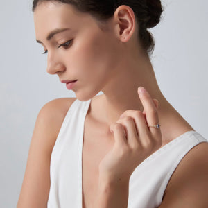Woman wearing a diamond ring on a plain background