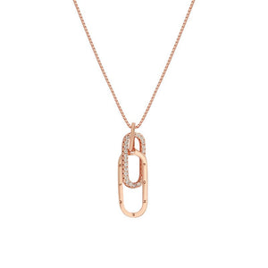 A gold-plated sterling silver letter interlocking pin pendant necklace with cubic zirconia, displayed on a yellow background.