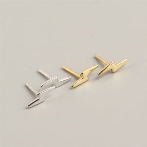 A set of sterling silver stud earrings with a lightning bolt design, displayed on a black surface.