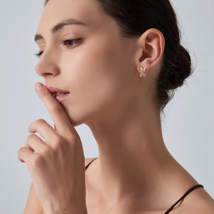 Woman wearing gold earrings with a neutral background