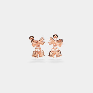 Rose gold bow-shaped earrings with dangling elements on a light gray background