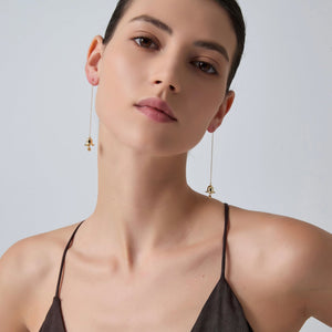 Woman wearing elegant earrings against a plain background