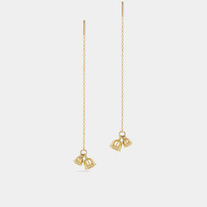 Gold bell-shaped earrings on thin chains against a white background