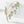 Gold leaf-shaped brooch with green gemstones on a white background