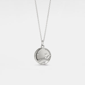 Silver necklace with a round locket featuring a fox and stars on a light gray background, inspired by 'The Little Prince'.