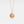 Rose gold necklace with a round locket featuring a fox and stars on a light gray background, inspired by 'The Little Prince'.